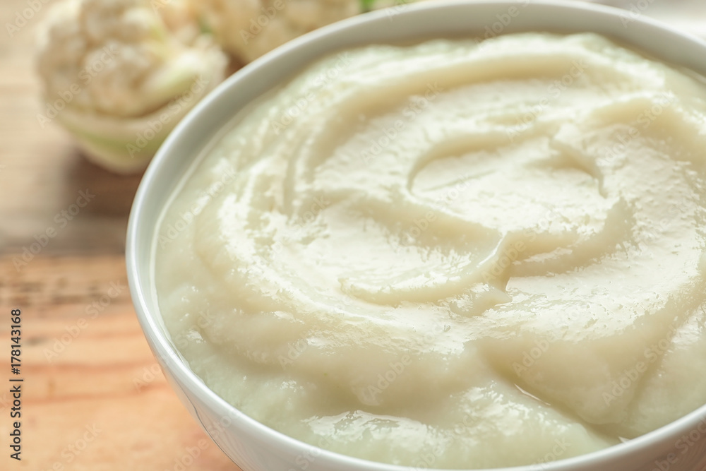 Ceramic bowl with baby food on blurred background, closeup Ceramic bowl with baby food on blurred background, closeup