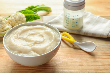 Ceramic bowl with baby food on table