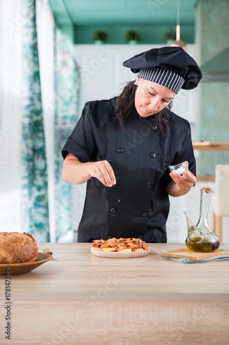 woman chef seasoning a dish