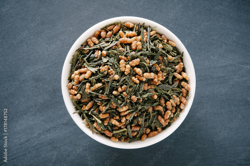 Bowl of Loose Green Genmaicha Tea Presented on a Black Chalkboard Surface Bowl of Loose Green Genmaicha Tea Presented on a Black Chalkboard Surface