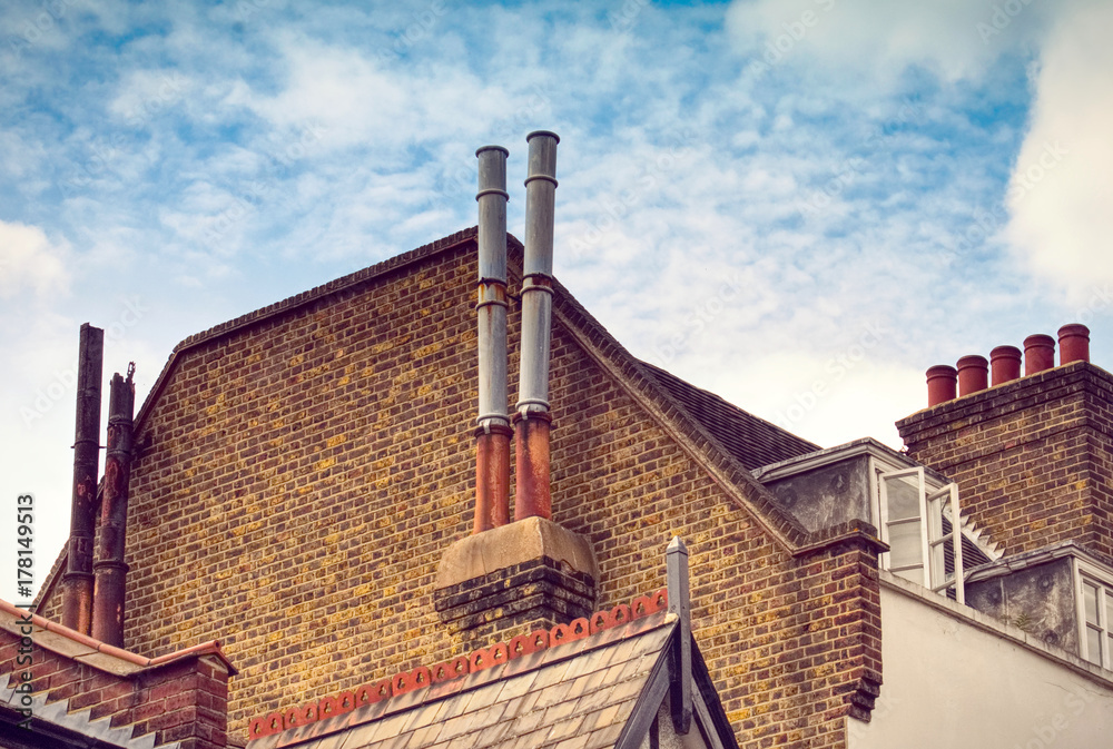 LONDON, UK Chimneys on rooftop over a typical ancient buildings in the royal borough of Greenwich. Light washed up instagram effect applied.