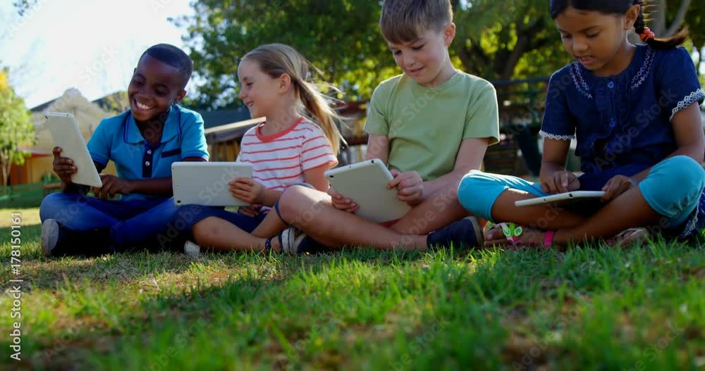 African American and mixed-race kids using digital tablet in the playground African American and mixed-race kids using digital tablet in the playground