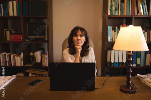 Portrait of confident woman using laptop at desk photo