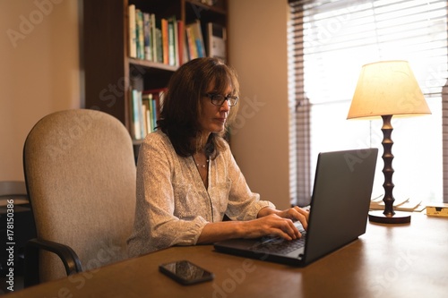 Attentive woman using laptop at desk photo