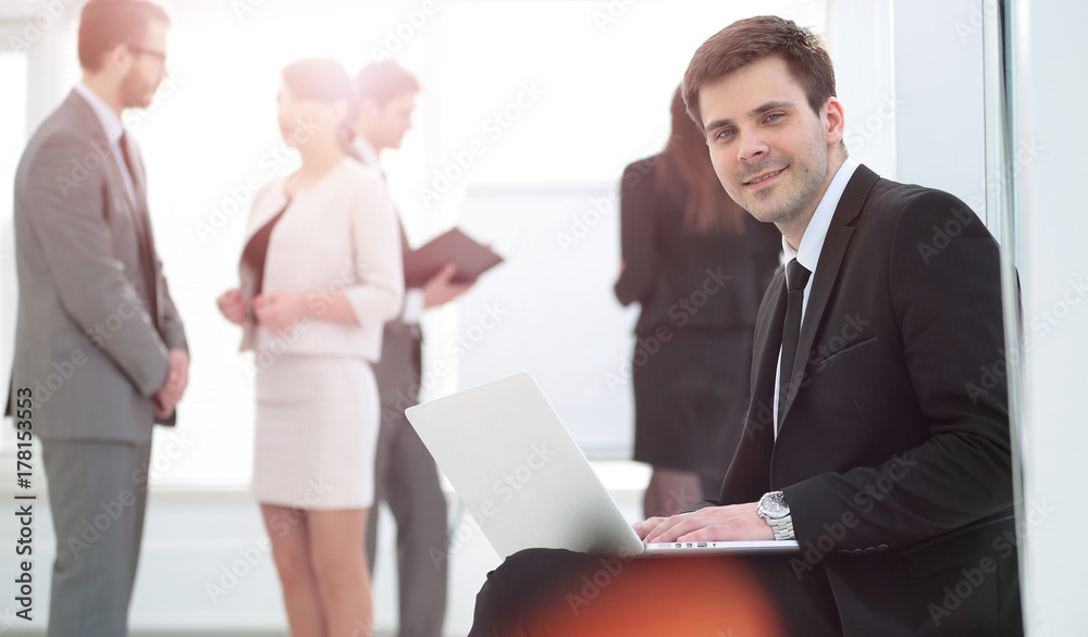 Fototapeta premium concept of the Internet: young smiling businessman with laptop s