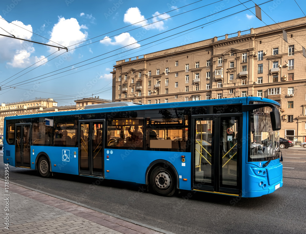 Blue bus on the street of a city. City transport development. Comfort for living.