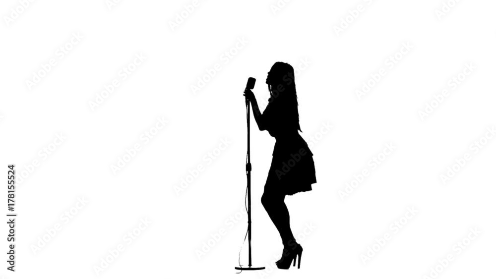 Woman sing song and dances near a retro microphone. Silhouette. White background. Slow motion Woman sing song and dances near a retro microphone. Silhouette. White background. Slow motion