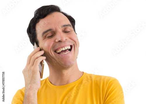 Radiant man talking on the phone and laughing. He's on his feet. Isolated on white background..