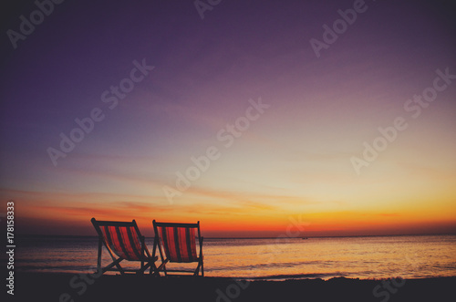 Two (2) empty and inviting beach chairs next to the sea during beautiful sunset on Koh Lanta island photo