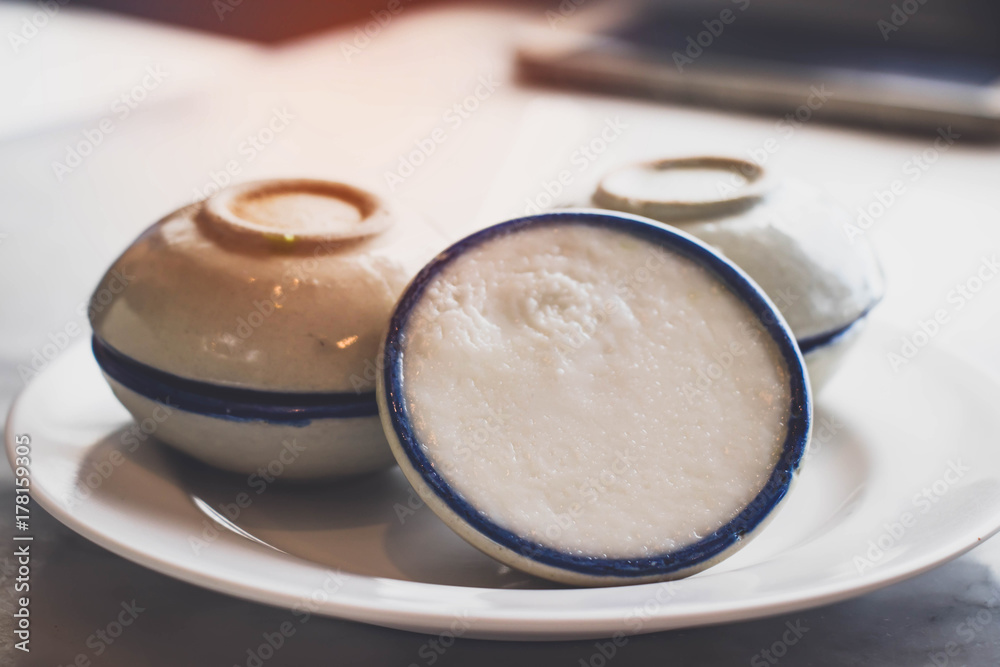 Thai dessert (khanom thuay) coconut milk custard in small porcelain cup . Thai dessert (khanom thuay) coconut milk custard in small porcelain cup .