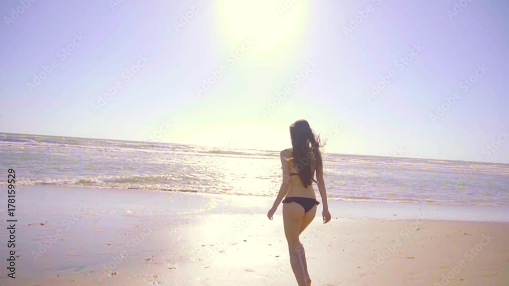 Beautiful woman running in bikini on beach in a sunny day. Sexy girl enjoying the sun, the water and the weather in the beach Beautiful woman running in bikini on beach in a sunny day. Sexy girl enjoying the sun, the water and the weather in the beach