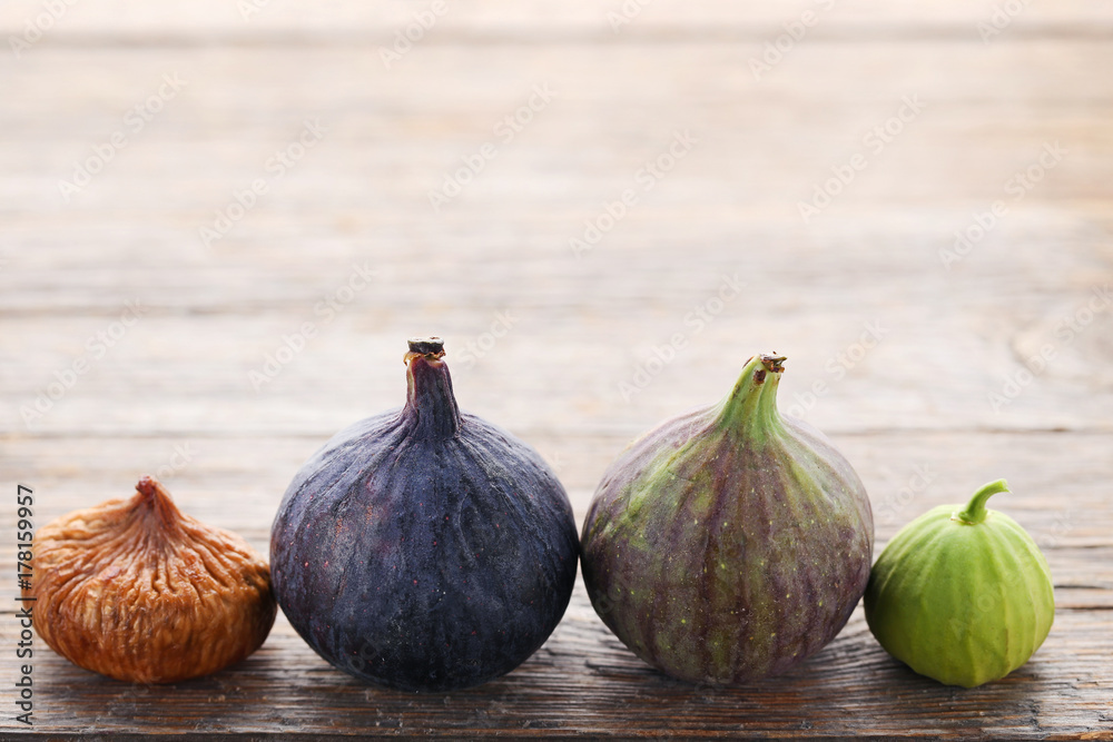 Obraz premium Ripe, dried and green figs on wooden table