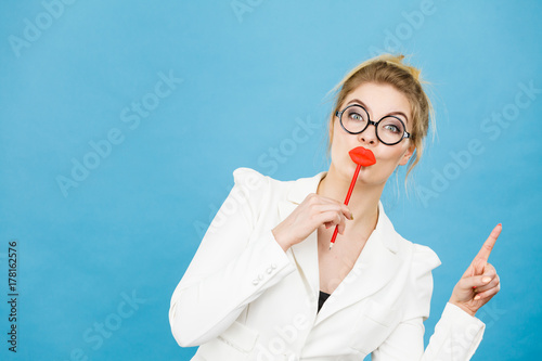 woman holds fake lips on stick pointing at copy space