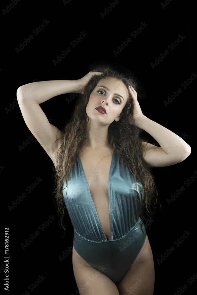 Wet look from a cute woman, studio in black background, wet skin and hair, wear blue shine one piece swimsuit Wet look from a cute woman, studio in black background, wet skin and hair, wear blue shine one piece swimsuit