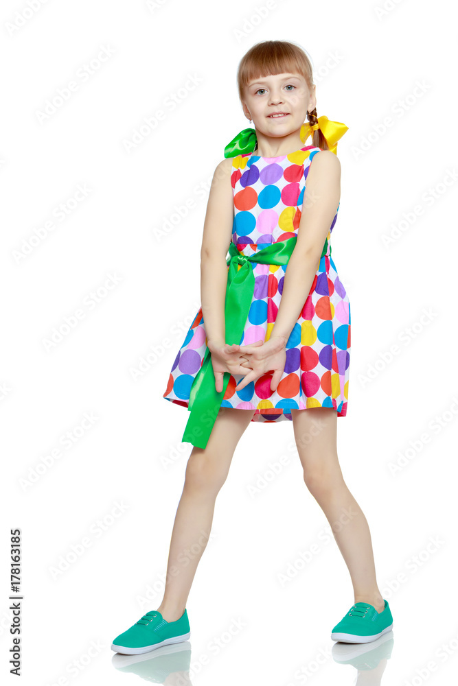 A little girl in a dress with a pattern from multi-colored circl A little girl in a dress with a pattern from multi-colored circl