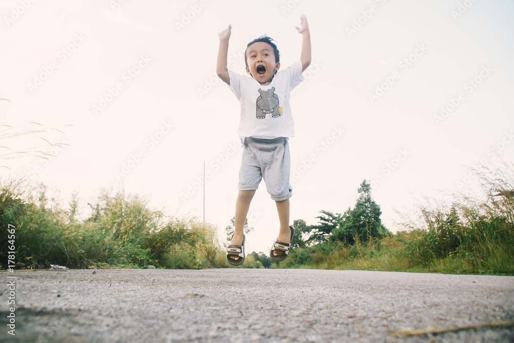 Fototapeta premium Healthy And Cheerful Asian Kids Is Jumping Happily , Outdoor