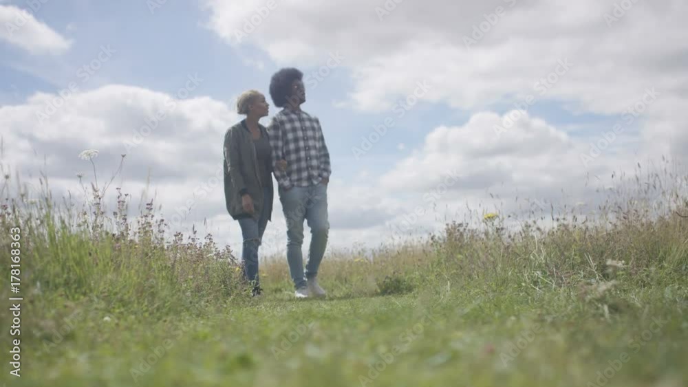  Happy couple taking a walk in the countryside on a sunny day