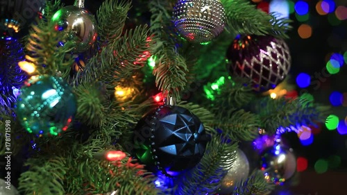 Christmas tree with ornaments on with flickering and color changing lights in different colors in part in holiday season photo