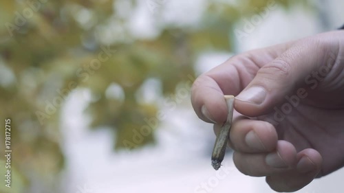 Down And Depressed Man hand with a cigarette outdoor. In Sign Of Stressful Work Conditions And Economic Uncertainty photo