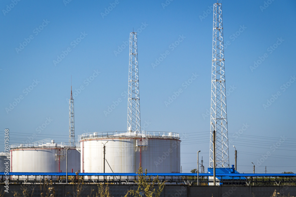 White large oil storage tanks against the blue sky. White large oil storage tanks against the blue sky.