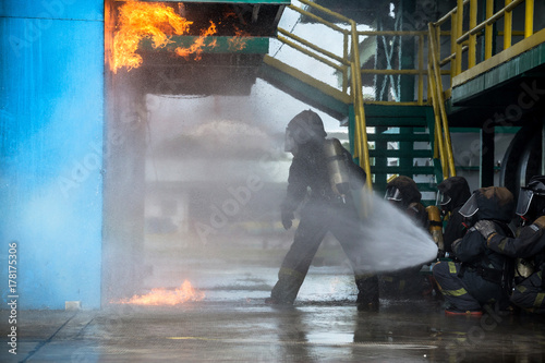 Wallpaper Mural Firemen using water from hose for fire fighting at firefight training of insurance group. Firefighter wearing a fire suit for safety under the danger case. Torontodigital.ca
