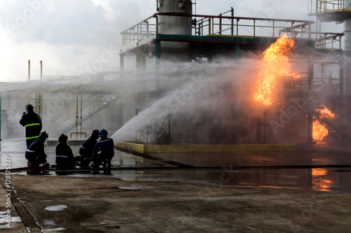 Wallpaper Mural Firemen using water from hose for fire fighting at firefight training of insurance group. Firefighter wearing a fire suit for safety under the danger case. Torontodigital.ca