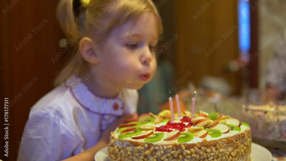 Little girl blowing out candles on a cake Little girl blowing out candles on a cake