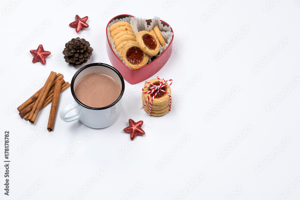 Cup of hot chocolate with cinnamon sticks, christmas cookies with jam in heart shaped red box on white background. Christmas decoration. Cup of hot chocolate with cinnamon sticks, christmas cookies with jam in heart shaped red box on white background. Christmas decoration.