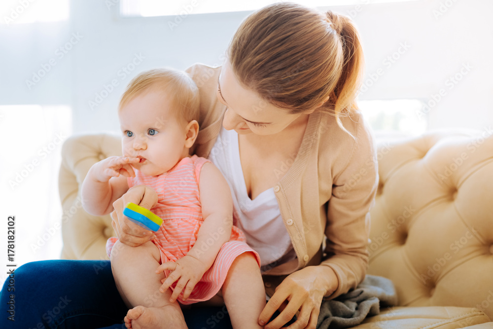 Loving kind mother showing a new bright toy Loving kind mother showing a new bright toy