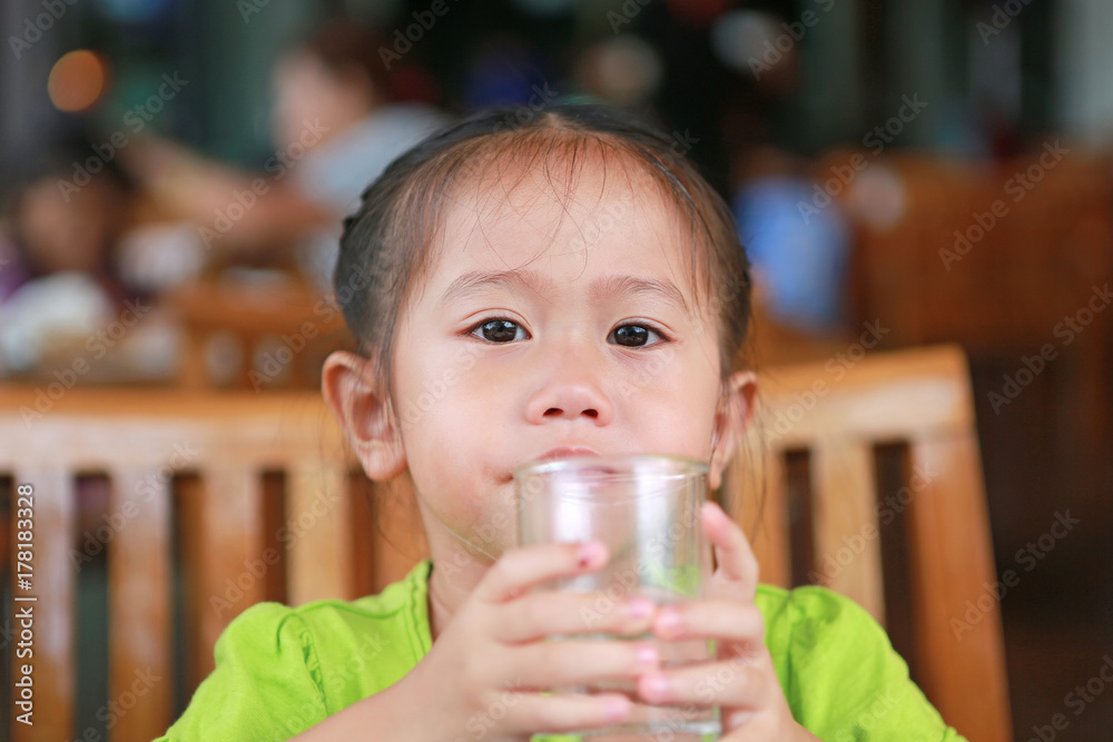 Asian little girl is drinking a water from glass after meal.
Asian little girl is drinking a water from glass after meal.