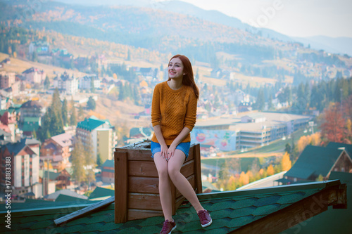 Fototapeta Naklejka Na Ścianę i Meble -  Beautiful young pretty casual fashion lady on roof top having relax time, lifestyle people concept. Cute sad girl sitting on the roof. Back view of cheerful young woman. Freedom concept.