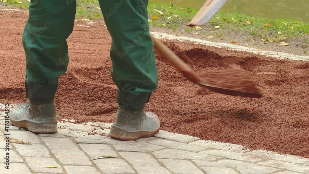 Compacting the Road Surface. Improvement of pedestrian zones of the city. A worker with a special machine Rams sand. 