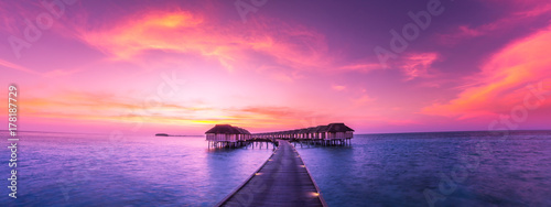 Luxury water bungalow in sunset time. Amazing colors and seascape view photo