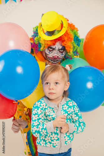 a terrible clown and a child. Halloween. The crazy clown. Childish fear