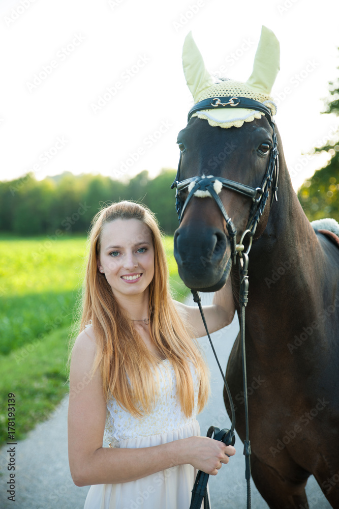 Obraz premium Beautiful young woman with horse outdoor on a walk in nature