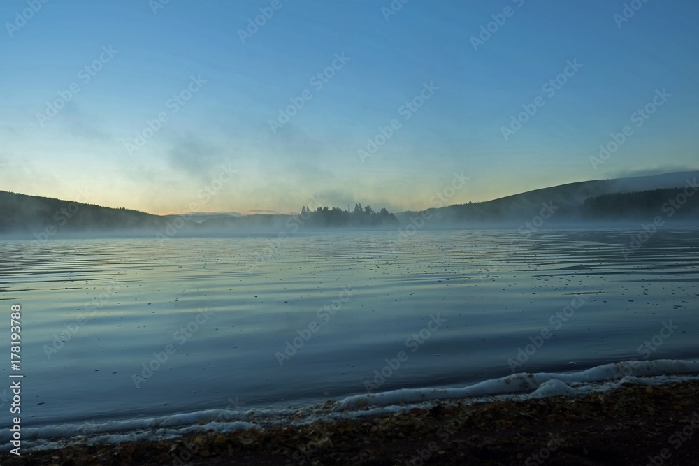 Autumn Mist rises from a highland loch at sunrise
