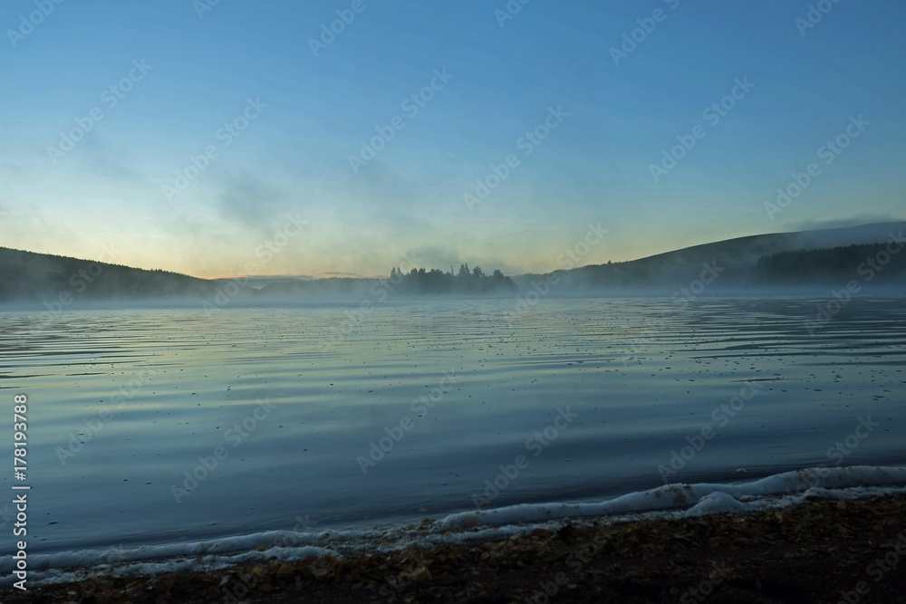 Obraz premium Autumn Mist rises from a highland loch at sunrise