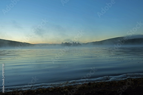 Autumn Mist rises from a highland loch at sunrise