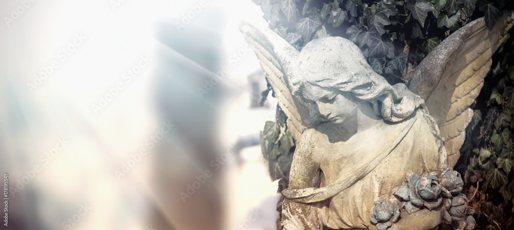 Fototapeta premium Vintage obraz smutnego anioła na cmentarzu. Antyczny posąg.