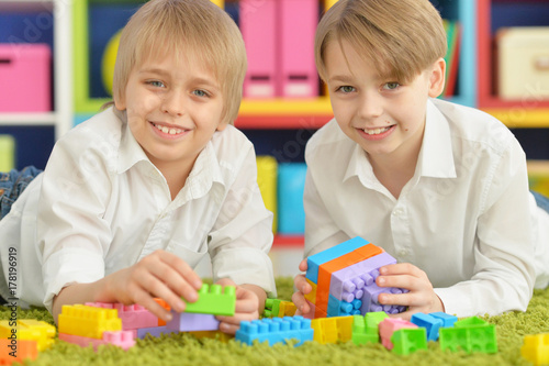 boys playing with colorful plastic blocks 