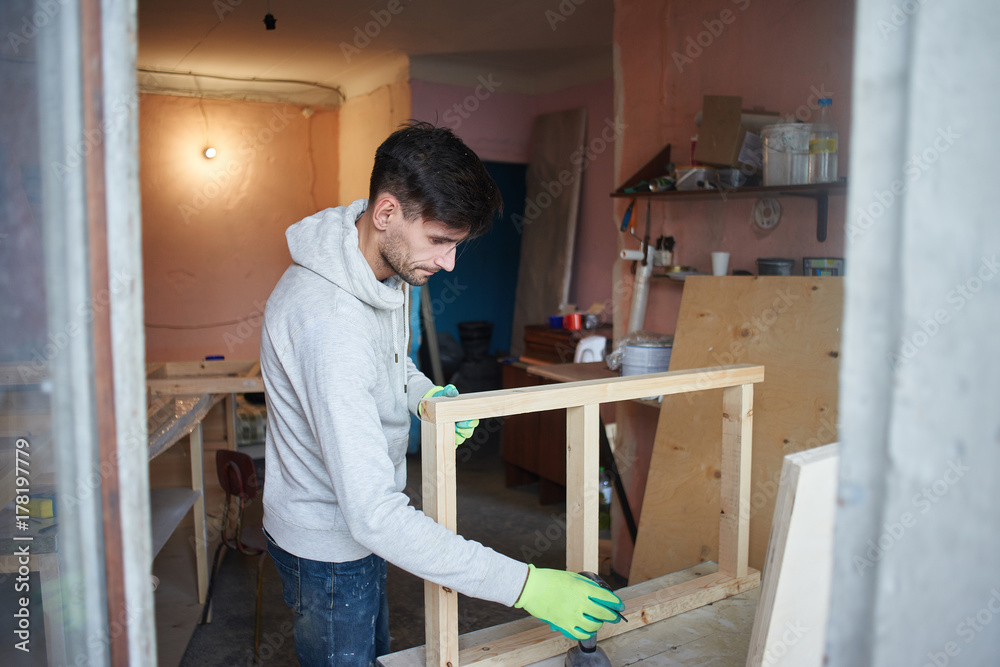 Portrait of a guy working in a home workshop. Portrait of a guy working in a home workshop.