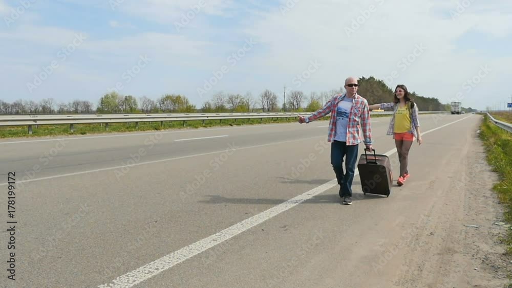 People walk along the road and catch the car hitchhiking People walk along the road and catch the car hitchhiking