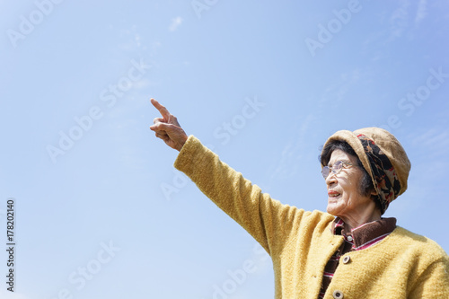 Elderly woman pointing to the sky