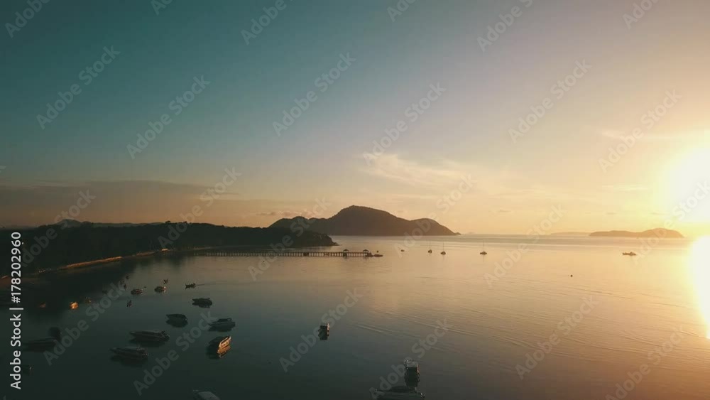 Sunrise bay in tropical island with reflected calm water and clouds aerial shot Sunrise bay in tropical island with reflected calm water and clouds aerial shot