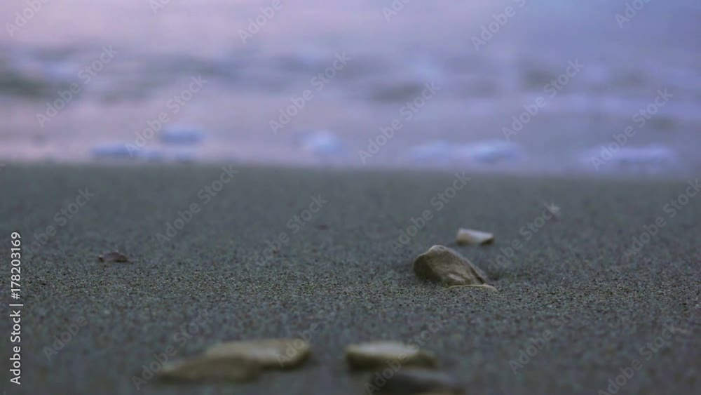 Sea tidal wave at night splashing pebbles at sandy beach Sea tidal wave at night splashing pebbles at sandy beach