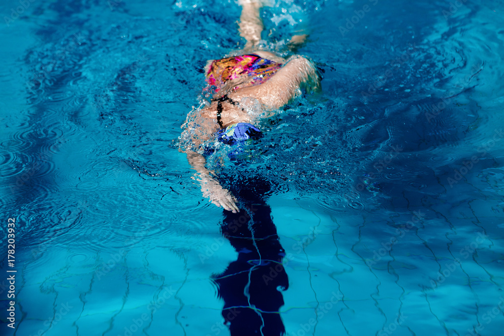 woman swimming with swimming hat in swimming pool