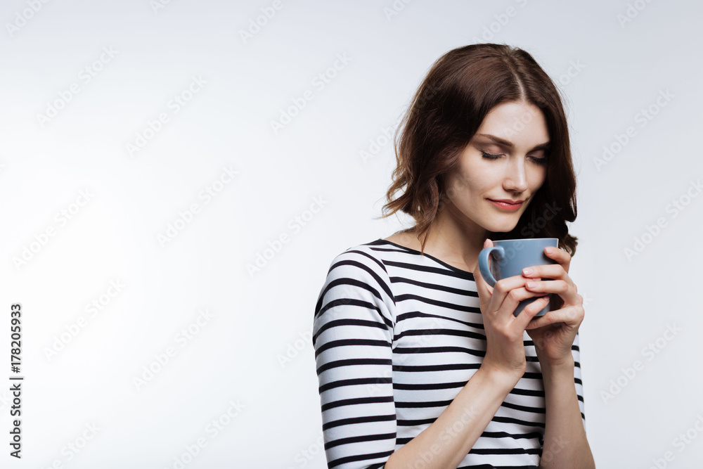 Auburn-haired woman enjoying scent of coffee Auburn-haired woman enjoying scent of coffee