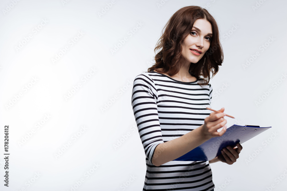 Charming young woman making notes with pencil Charming young woman making notes with pencil