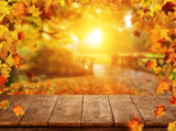 Autumn background with falling leaves and empty wooden table