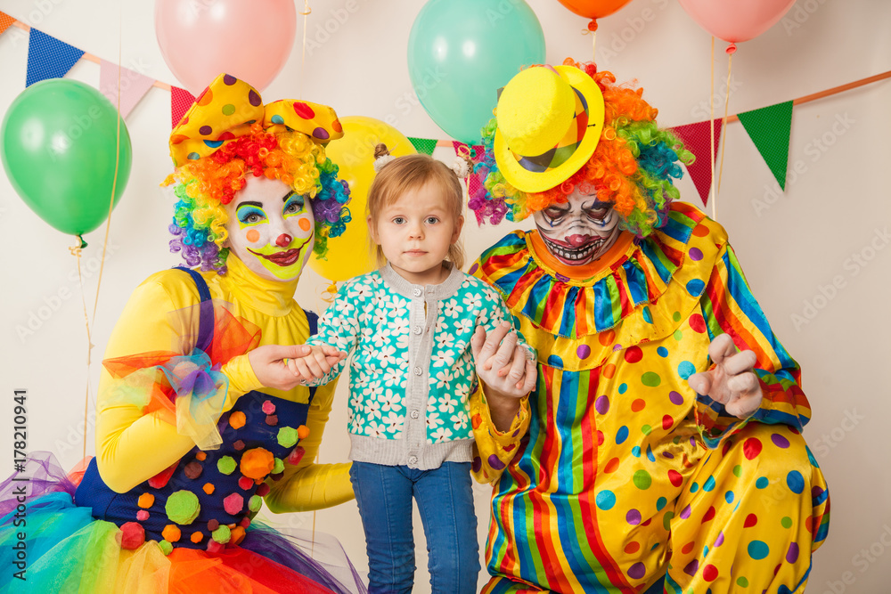 a terrible clown and a good clown with a child. Halloween. The crazy clown and clowness. Little girl a terrible clown and a good clown with a child. Halloween. The crazy clown and clowness. Little girl